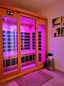 una stanza con luci viola sulle porte di Detente Nature bord de Lac #3 Spa Sauna & Foyer a Sainte Brigitte de Laval