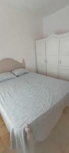 a bedroom with a white bed and white cabinets at Casa dos Buizinhos in Porto Covo