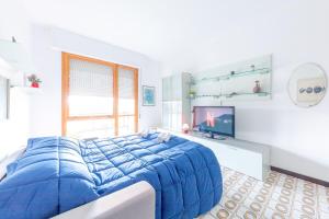 a bedroom with a blue bed and a television at Portofino - Near the Sea, Pool -Tennis - Wifi in Rapallo