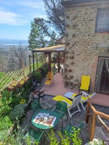 Rustico La Tinaia في Montigiano: فناء فيه كراسي وطاولة وكراسي