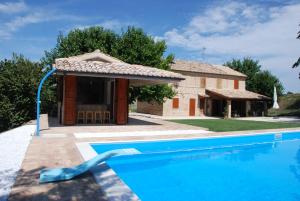 a swimming pool in front of a house at B&B Profumo delle Marche in Montefano