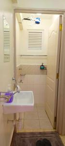 a white bathroom with a sink and a shower at Cozy Escape in Ongata Rongai 