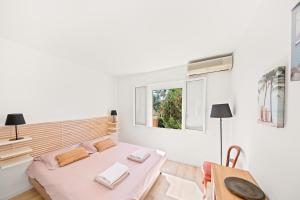 a bedroom with a bed and a table and a window at Vue Mer I Calme I Verdoyant I 8 Pers I Clim I BBQ in Hyères