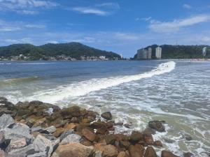 a beach with some rocks in the water at Flat da Belly 904-A Hidro Piscina Praia in São Vicente