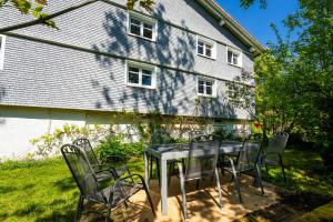 ein Tisch und Stühle vor einem Haus in der Unterkunft Mit Blick auf Bergwiesen - Familienfreundliches Bauernhaus im Westallgäu in Weiler-Simmerberg