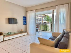 a living room with a couch and a television at Beach Living Pé na Areia por Be My Guest in Aquiraz