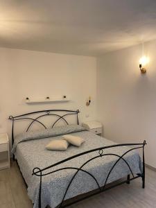 a bedroom with a bed with two pillows on it at Casa Miramar e Casa Solemar in Santa Teresa Gallura