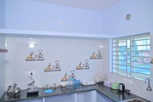 a kitchen with a counter top with a window at Roy Service Apartment in Chikmagalūr