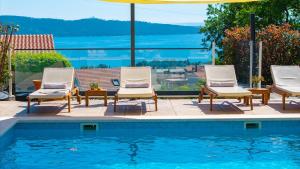 a group of chairs sitting next to a swimming pool at Seaview Villa Stanka with Pool and attached Jacuzzi in Kaštela +38 photos