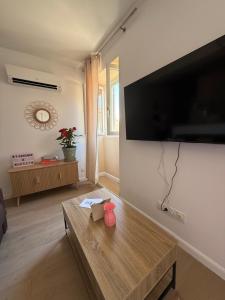een woonkamer met een grote flatscreen-tv aan de muur bij T2 Cosy HYPER CENTRE AJACCIO in Ajaccio
