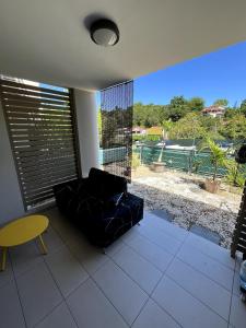 Una sala de estar con un sofá y una ventana grande. en appartement T2 Soléia Zen, en Le Gosier 4 fotos más