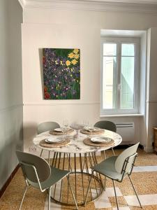 a dining room with a table with chairs and a painting at Maison Paulette - charme et authenticité in Bizanet