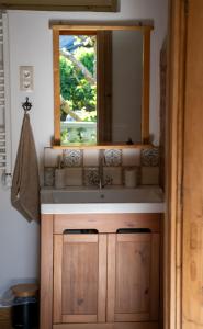 lavabo con espejo y ventana en Mokka Vendégház, en Kismaros
