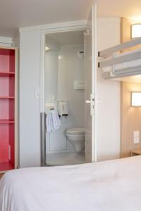 a bedroom with a bed and a bathroom with a toilet at Premiere Classe Nantes Est St Sebastien Sur Loire in Saint-Sébastien-sur-Loire