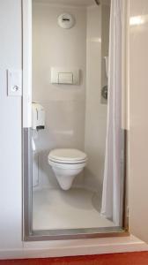 a bathroom with a toilet and a shower curtain at Premiere Classe Nantes Est St Sebastien Sur Loire in Saint-Sébastien-sur-Loire