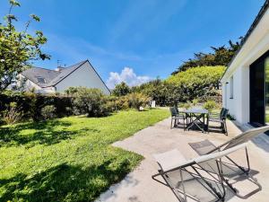 a patio with chairs and a table in a yard at Villa 7 pièces à Quiberon - Proche plage, jardin, parking, WiFi - FR-1-478-307 in Quiberon
