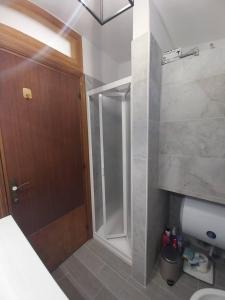 La salle de bains est pourvue d'une douche et d'une porte en bois. dans l'établissement Fpo-Fio42tp Casa su due Piani, 6 Pax A Ottiolu, à Porto Ottiolu