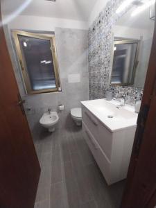 une salle de bain avec un lavabo, des toilettes et un miroir dans l'établissement Fpo-Fio42tp Casa su due Piani, 6 Pax A Ottiolu, à Porto Ottiolu 6 autres photos