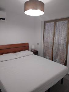 une chambre avec un grand lit blanc et une fenêtre dans l'établissement Fpo-Fio42tp Casa su due Piani, 6 Pax A Ottiolu, à Porto Ottiolu