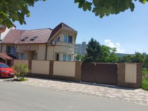 a house with a fence in front of a street at Zajer Apartment Ház in Hajdúszoboszló