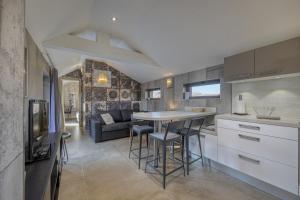 a kitchen and living room with a table and chairs at Le Pigeonnier - Vue sur le château de Menthon in Menthon-Saint-Bernard