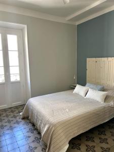 a bedroom with a large bed and a window at Maison Paulette - charme et authenticité in Bizanet