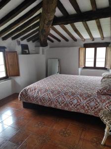 Un dormitorio con una cama en una habitación con suelo de madera. en Traditional Tuscan Farmhouse Lucca District - sleeps 6, en Diecimo