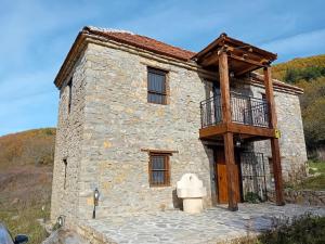 a stone house with a balcony on the side of it at Arbinovo Lodge in Ohrid