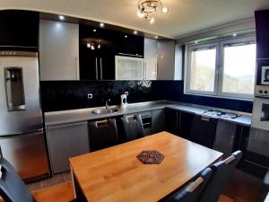 a kitchen with a wooden table and a sink at Villa Nature Sarajevo in Sarajevo