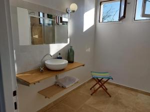 a bathroom with a white sink and a chair at Domaine isolé dans les vignes avec sa jacuzzi house in Beaulieu-sur-Loire +13 photos
