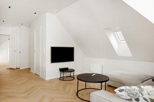 a white living room with a couch and a tv at Bergen City Living in Bergen