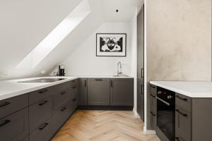 a kitchen with gray cabinets and a white counter top at Bergen City Living in Bergen