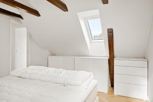a white bedroom with a bed and a window at Bergen City Living in Bergen