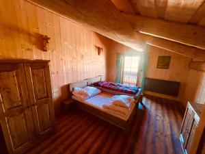 a bedroom with a bed in a wooden room at Zrub Sova - Važec - 3 bedroom - 2 bathroom in Važec