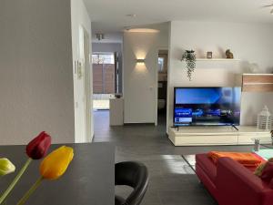 a living room with a large tv and a couch at AAM Ferienwohnung 75qm Saarlouis citynah PP WiFi in Saarlouis