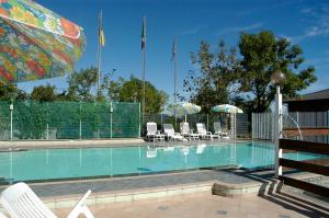 - une piscine bordée de chaises et de parasols dans l'établissement Hotel Al Poggio, à Sestola