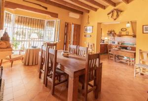 Un comedor con mesa y sillas de madera. en Casa Rural Santa Ana, en Marchena