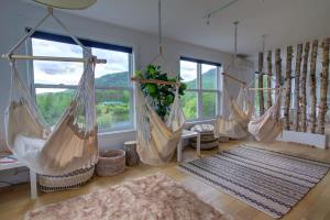 a room with four hanging hammocks and a rug at Detente Nature bord de Lac #5 - Spa Sauna & Foyer in Sainte Brigitte de Laval
