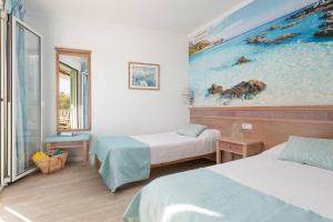 a room with two beds and a painting on the wall at Apartamentos Playa Marina in Cala Ferrera