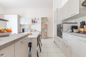 a kitchen with white cabinets and a table with fruits on it at il terrazzino di Marco e Francesca in Siena +19 photos