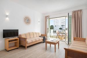 salon z kanapą i telewizorem w obiekcie Apartamentos Playa Marina w mieście Cala Ferrera