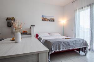 a white bedroom with a bed and a table at il terrazzino di Marco e Francesca in Siena