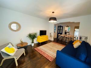 a living room with a blue couch and a yellow chair at 3 Bedroom Apartment with Backyard Oasis (1T) in Miami