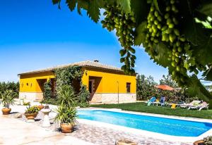 a yellow house with a swimming pool in front of it at Casa Rural Villa Lucrecia in La Lantejuela