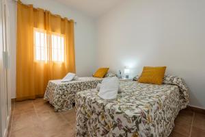 a room with two beds and a window at Casa Rural Maria in La Lantejuela +27 photos
