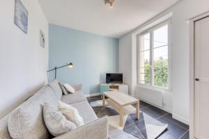 a living room with a couch and a table at Le Scandi Bleu - Proche Gare Corbeil - Cozy Houses in Corbeil-Essonnes