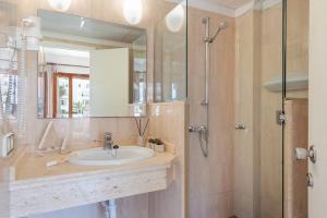 łazienka z umywalką i prysznicem z lustrem w obiekcie Apartamentos Playa Marina w mieście Cala Ferrera +37 zdjęć