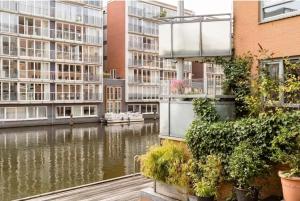 une vue d'une rivière avec des bâtiments et des plantes dans l'établissement SM Center located room on the canal, à Amsterdam