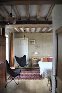 a bedroom with a bed and a desk and chairs at Doué's Mansion in Doué-la-Fontaine