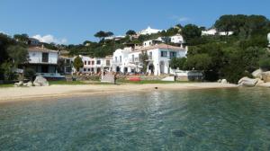 un gruppo di case su una spiaggia vicino all'acqua di Villa Sycorax, waterfront with private jetty and buoy a Porto Rafael